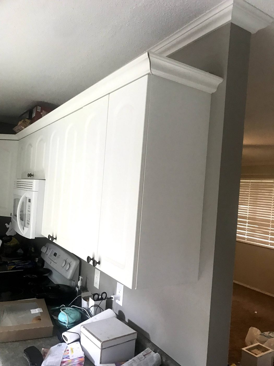 White painted built-in cabinetry with crown molding in a finished interior
