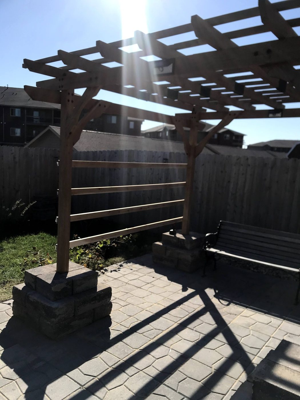 Custom-built wooden pergola over a paver patio
