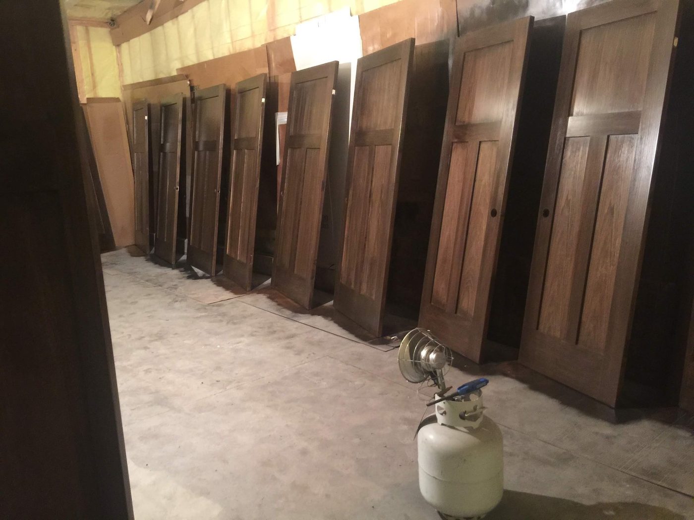 Row of stained wood doors finished and standing ready for installation