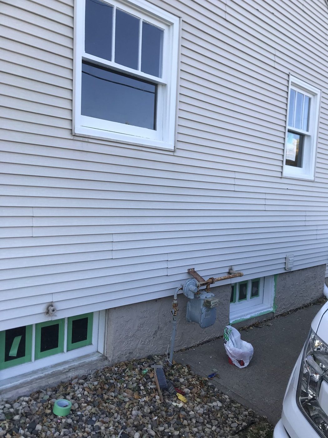 Freshly painted white siding and window trim on a residential exterior